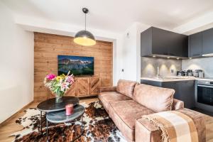 a living room with a couch and a table at Apartment Redwood Alpe D'Huez - by EMERALD STAY in LʼHuez