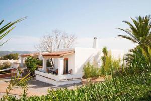 a small white house with a palm tree at Residencial Bogamar&iacute; in San Antonio Bay