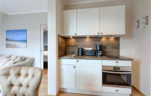 a kitchen with white cabinets and a counter top at Baltischer Hof Apartment 52 in Boltenhagen
