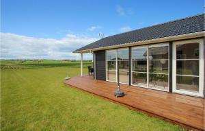 NordbyにあるCozy Home In Samsø With Wifiの田地に隣接する木製のデッキ付きの家 +12枚の写真