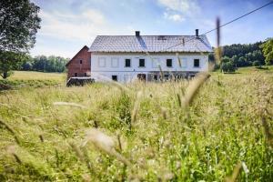an old white house in the middle of a field at Statek 85 in Mařenice