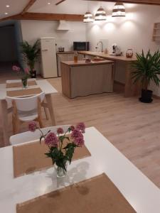 a kitchen with a table with flowers on it at L'Oustal Roja in Saint-Affrique