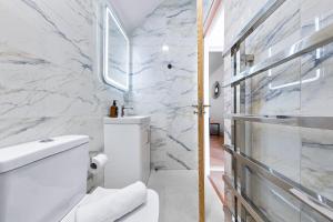 a white bathroom with a toilet and a shower at Stylish 4 bedroom I extended stays I contractors in Harrow +24 photos