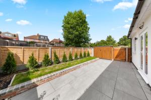 a backyard with a fence and a concrete patio at Stylish 4 bedroom I extended stays I contractors in Harrow