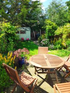 una mesa de madera y sillas en un patio en Stylish Victorian House, en Watford