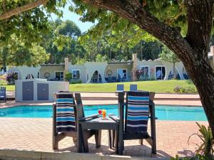 two chairs and a table in front of a pool at Lodge Azure in Port Edward