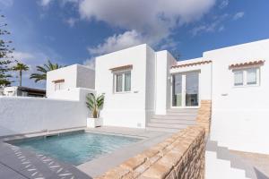a white villa with a swimming pool at Residencial Bogamar&iacute; in San Antonio Bay