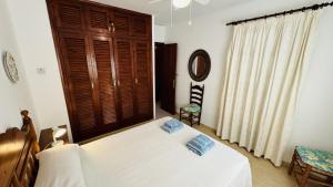 a bedroom with a white bed and a wooden door at Mulberry in Son Bou +17 photos