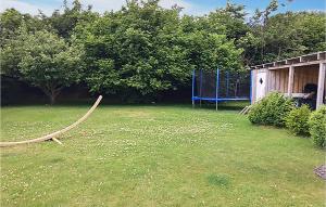 a large yard with a swing set in the grass at Three-Bedroom Holiday Home In Sydals in Skovbyballe