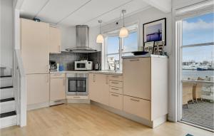 a kitchen with white cabinets and a large window at Hummeren 164 in Ebeltoft