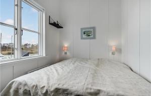 a white bedroom with a bed and two windows at Hummeren 164 in Ebeltoft +25 photos