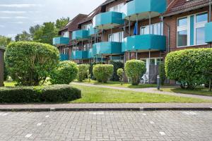 a building with bushes in front of it at Ferienwohnung 12 im Haus Borkum in Dorum Neufeld