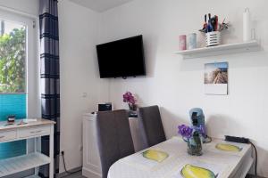 a dining room with a table and a tv on the wall at Ferienwohnung 12 im Haus Borkum in Dorum Neufeld