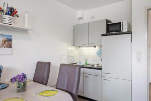 a small kitchen with a table and a white refrigerator at Ferienwohnung 12 im Haus Borkum in Dorum Neufeld