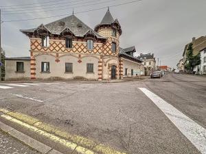 an old building on the side of a street at Charmant Duplex au Cœur Vosgien in Charmes