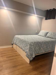 a bedroom with a bed and a wooden floor at Bowmanville apartment in Bowmanville