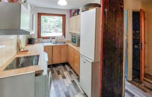 a kitchen with a white refrigerator and wooden cabinets at Cap Ferret Villa Grand Chalet Bois in Lège-Cap-Ferret