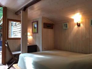 a bedroom with a bed in a room with a window at Cap Ferret Villa Grand Chalet Bois in Lège-Cap-Ferret