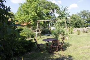 a table and chairs in a garden with a swing at Damwildhof Fewo zur Linde in Blievenstorf
