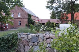 a stone retaining wall in front of a house at Damwildhof Fewo zur Linde in Blievenstorf