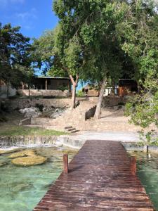 a wooden bridge over a body of water at Casa Piedra de Agua Bacalar in Bacalar +33 photos
