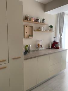 eine Küche mit weißen Schränken und einer Arbeitsplatte in der Unterkunft Anda3 in Mamaia