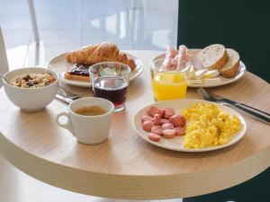 a table topped with plates of breakfast foods and coffee at B&B Hotel Faenza in Faenza
