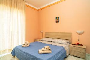 Un dormitorio con una cama azul con toallas. en La Casa Di Jano, en Francavilla di Sicilia