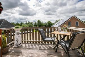 a wooden deck with a table and chairs on it at Ferienwohnung Huus 39 in Ostenfeld