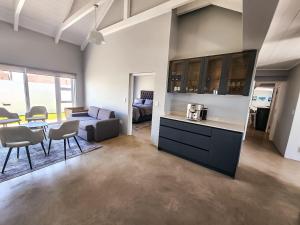 a kitchen and living room with a table and chairs at House JDV 20 Rooipypie in St. Helena Bay