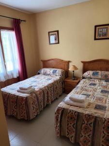 ガビンにあるApartamento EL PRADOのベッド2台と窓のある寝室