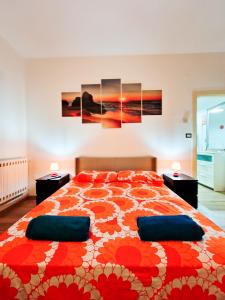 a bedroom with a large bed with red and orange flowers at Sunshine Apartment - Salerno in Salerno