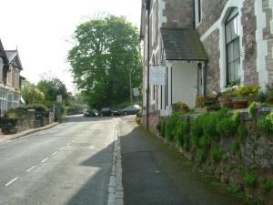 an empty street next to a house with a sign on it at Ashleigh House in Torquay
