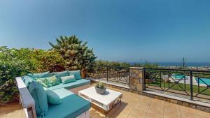 a patio with a couch and a table on a balcony at Villa Manetti with Private Pool and Garden by Hospi in Kokkíni Khánion