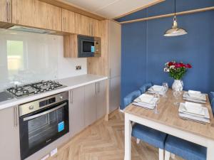 a kitchen with a table and a stove at Hazel Lodge in Whitby +42 photos