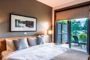 a bedroom with a bed and a sliding glass door at Lakefront Mountain View - 1 Bedroom Resort Suite in Lac-Superieur