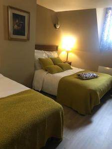 伊利耶Hotel de l image的酒店客房,配有两张带绿床单的床