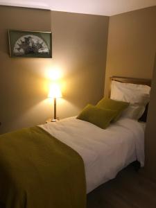 伊利耶Hotel de l image的卧室里有一张白色的大床，床边有一盏灯