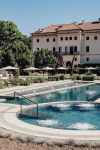 une grande piscine devant un immeuble dans l'établissement Villa Corallo, à SantʼOmero