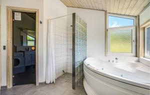 un bagno con vasca, lavandino e finestra di Holiday Home Nordbakken Ebeltoft Ix a Ebeltoft Altre 24 foto