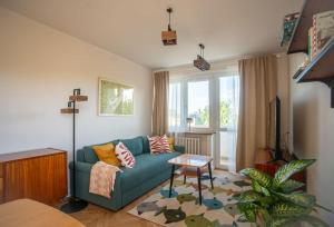a living room with a green couch and a window at ODPOCZINK 2-pokojowe mieszkanie w centrum in Gdynia