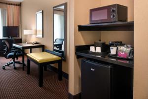 a hotel room with a desk and a chair and a television at Hampton Inn and Suites Ogden in Ogden