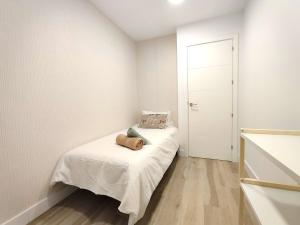 ein kleines Schlafzimmer mit einem Bett mit weißen Wänden in der Unterkunft Luxury Apartments Las Canteras in Las Palmas de Gran Canaria