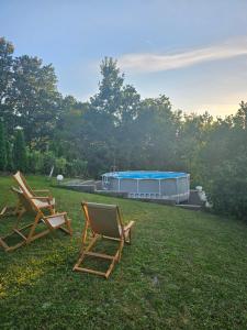 two lawn chairs and a tent in the grass at Topola vikendica in Topola