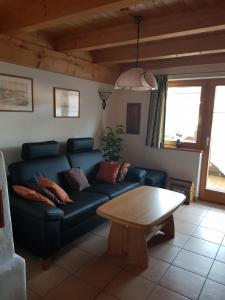 ein Wohnzimmer mit einem blauen Sofa und einem Tisch in der Unterkunft Ferienhaus in ruhiger Lage, mit Balkon und großer Terrasse in Aschau im Chiemgau