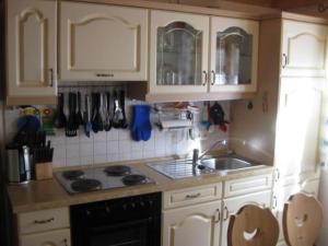 eine Küche mit weißen Schränken und einer Spüle in der Unterkunft Ferienhaus in ruhiger Lage, mit Balkon und großer Terrasse in Aschau im Chiemgau