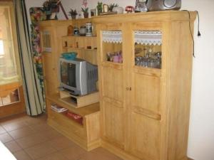 ein Holzschrank mit einem Fernseher in einem Zimmer in der Unterkunft Ferienhaus in ruhiger Lage, mit Balkon und großer Terrasse in Aschau im Chiemgau