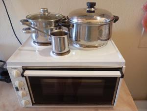 two pots and pans sitting on top of a stove at Blackmountain Sea Spot in Mavrovouni