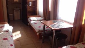 a room with two beds and a table and a desk at Pokoje u Ani in Zastań