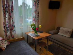 a living room with a table with a vase of flowers on it at Pokoje u Ani in Zastań